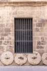 Casco Antiguo, Seville, Andalusia, Spain. Stone wheels being used in the foundation of a building. Art Print
